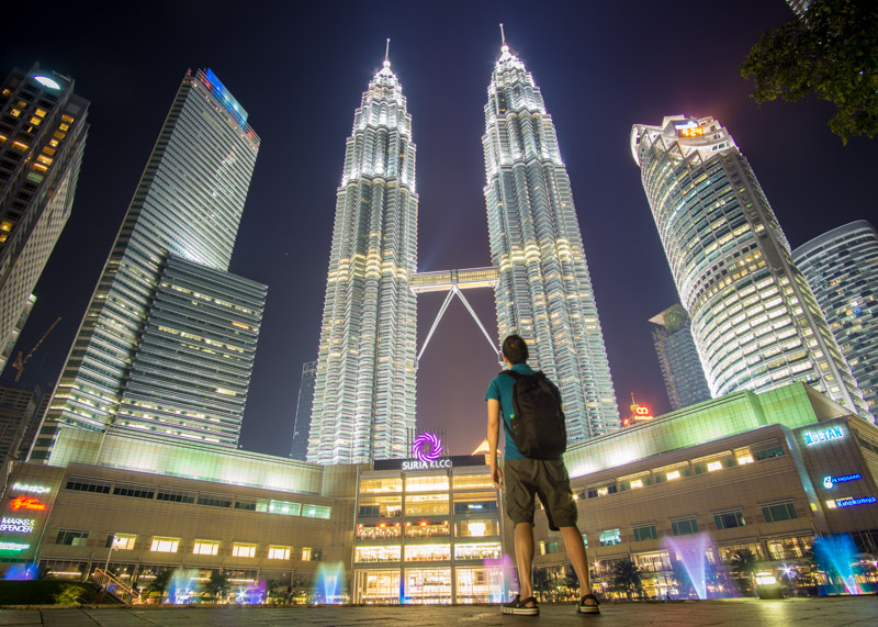 living as a nomad - petronas towers at night asian man